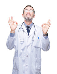 Middle age senior hoary doctor man wearing medical uniform isolated background relax and smiling with eyes closed doing meditation gesture with fingers. Yoga concept.