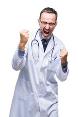 Middle age senior hoary doctor man wearing medical uniform isolated background very happy and excited doing winner gesture with arms raised, smiling and screaming for success. Celebration concept.