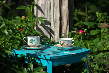 White China Teacups on Blue Table in Garden Double as Garden Art and Bird Baths