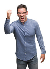 Fototapeta premium Handsome young elegant man wearing glasses angry and mad raising fist frustrated and furious while shouting with anger. Rage and aggressive concept.