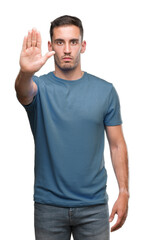 Handsome young casual man doing stop sing with palm of the hand. Warning expression with negative and serious gesture on the face.