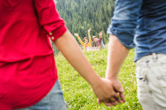 gl&uuml;ckliches Paar H&auml;ndchenhalten im Sommer in den Bergen mit Freunden, &Ouml;sterreich