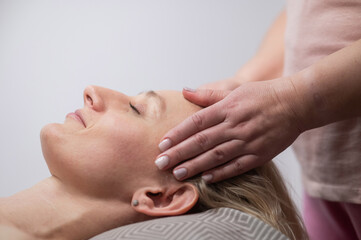 Fototapeta na wymiar Caucasian woman undergoing head and face massage procedure. 