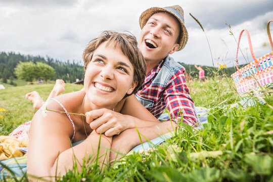 gl&uuml;ckliches Paar liegt in einer Wiese a in den Bergen, &Ouml;sterreich