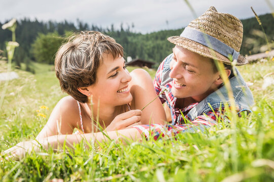 gl&uuml;ckliches Paar liegt in einer Wiese a in den Bergen, &Ouml;sterreich