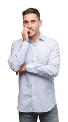 Handsome young businessman looking stressed and nervous with hands on mouth biting nails. Anxiety problem.