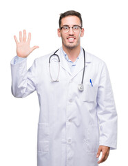 Handsome young doctor man showing and pointing up with fingers number five while smiling confident and happy.