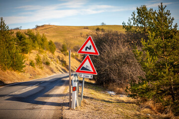A road sign informing about a street with a significant slope and sharp turns