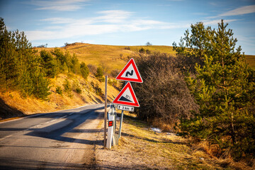 A road sign informing about a street with a significant slope and sharp turns