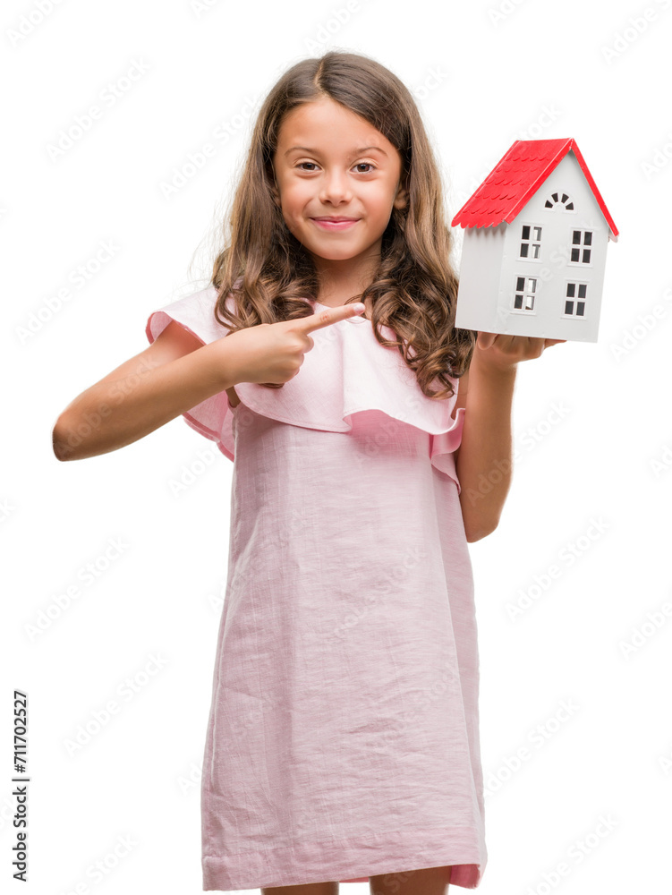 Wall mural brunette hispanic girl holding little house very happy pointing with hand and finger