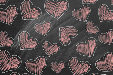 Many red hearts are drawn with chalk on the school chalkboard. Valentine's Day, love, compassion concept.
