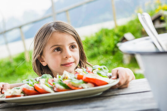 Portrait M&auml;dchen mit Salat an einer H&uuml;tte, &Ouml;sterreich