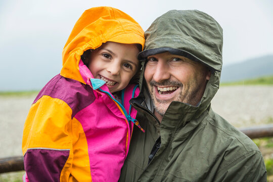 happy father and kid in raincoats having fun close portrait