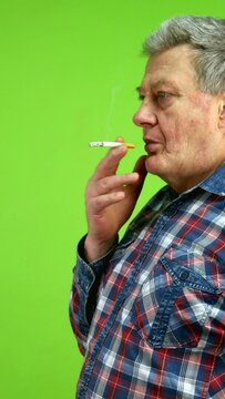 Man smoking cigarette relaxing and blowing smoke.