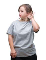 Young adult woman with down syndrome over isolated background smiling with hand over ear listening an hearing to rumor or gossip. Deafness concept.