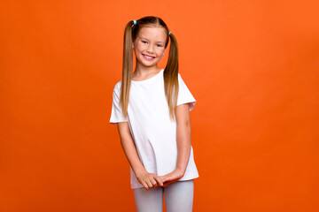 Photo portrait of pretty small girl cute charming shy posing dressed stylish white outfit isolated on orange color background