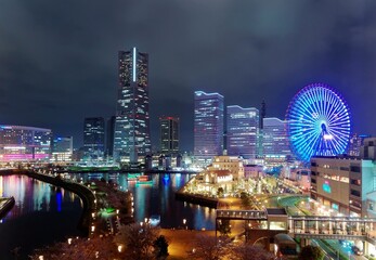 Night scape of Minatomirai Bay Area in Yokohama, Japan, with Landmark Tower amid high rise...