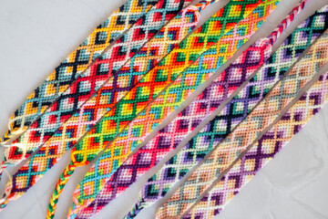Bracelets brésiliens colorés - bracelets réalisés à la main sur une table en marbre - fabrication artisanale de bracelets d'amitié