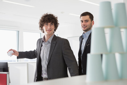 zwei M&auml;nner im Businessoutfit beim Dosenwerfen im B&uuml;ro, M&uuml;nchen, Deutschland