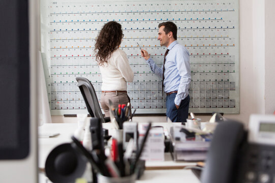 entrepreneurs couple portrait at work on big flipchart calender