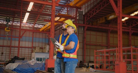 Fototapeta premium Workers partners in uniform Talking on a Meeting in Metal Construction Manufacture industry factory, Engineers man colleagues industrial discussing project work in warehouse. Team work