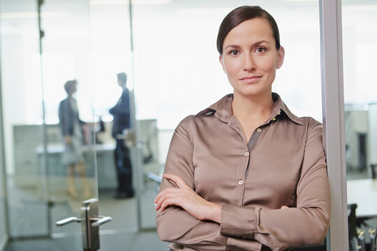 colleagues standing in big glass-walled conference room 
