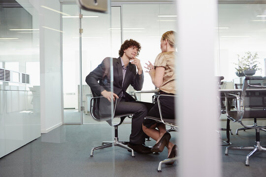 business people arguing  in a glass-walled conference room 