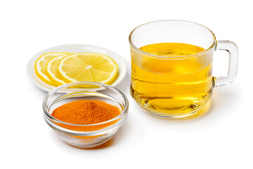 Glass with fresh made hot Curcuma drink and lemon isolated on white background