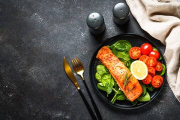 Grilled salmon fillet with fresh salad. Healthy food, Keto diet, low carb. Flat lay at black.