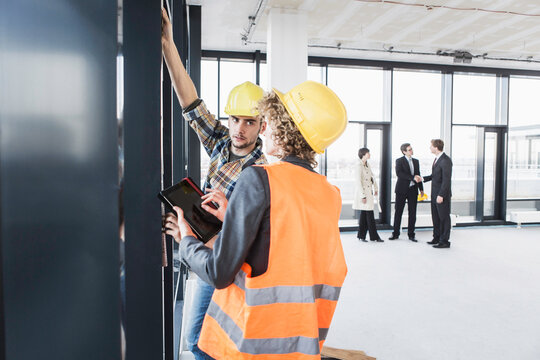 developer, owner and architect of new building inspecting the progress