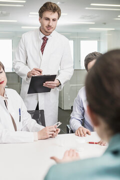 Colleagues at a pharmaceutical company meeting with clients in a conference room. Munich, Bavaria, Germany