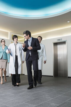 Colleagues at a pharmaceutical company meeting with a client in the foyer. Munich, Bavaria, Germany