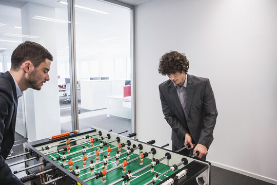Colleagues at a pharmaceutical playing foosball together. Munich, Bavaria, Germany