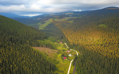 Aerial drone panorama above Sebes valley, at sunset. The mountain stream flows along grassy glades...