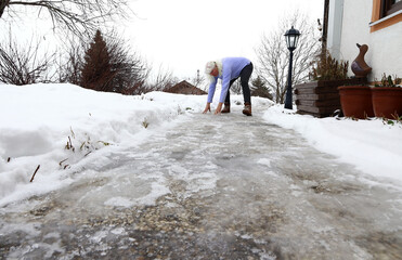 Rutschgefahr auf einem eisglatten Gehweg im Winter