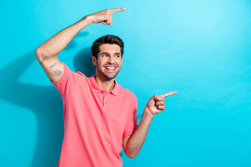 Photo portrait of young handsome man wearing pink t shirt directing fingers empty space news...