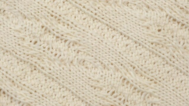 Soft Knitted Woolen Detailed Texture. Natural Fabric Closeup Knit Pattern. White Knitwear, Warm Cashmere Surface. Rotation, Macro. Cozy Textile Background. Clothes Production. Melange Yarn. 4K Shot	
