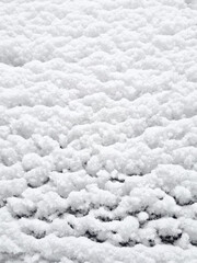 Snow on the roof of a car in winter. Close-up