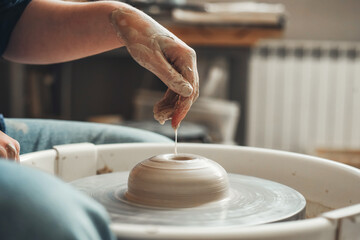 The hands of a Ceramist create pottery on a pottery wheel. Pottery, female hands of a potter...
