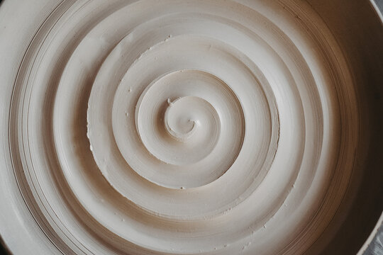 A beautiful spiral, a helical line on a clay surface. Pottery, clay texture decorated with a spiral notch. Abstract clay background Macro, top view