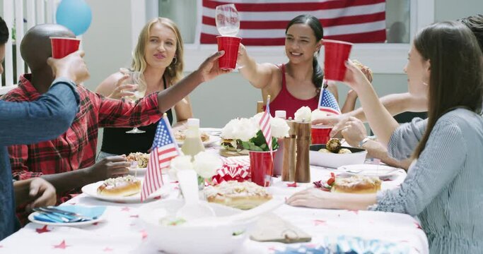 Friends, drinks and cheers at party, American flag and celebration for Independence Day with bbq outdoor. Diversity, fun and alcohol on fourth of July, national holiday and people with toast in USA