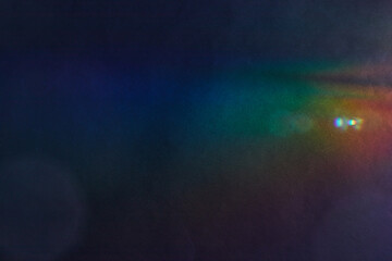 Soft Bright multicolored glare on dark rough textured cardboard. Soft rainbow light. Abstract...