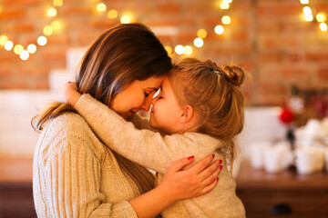 Beautiful woman and her daughter hugging indoors - obrazy, fototapety, plakaty