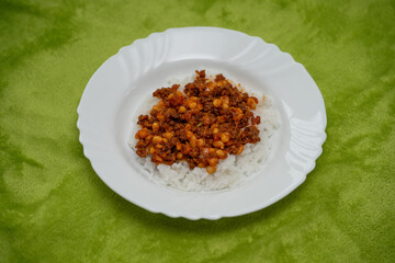 Chilli con carne with rice on a white plate.