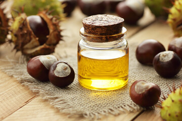 Hourse chestnut oil or extract with seeds on wooden rusric table, closeup, copy space, green...