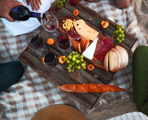 People drinking red wine outdoor. Summer picnic on the beach