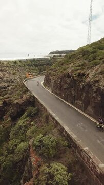 Race of cyclists in the Canary Islands, Cyclists between Mountains, Difficult Roads of Gran Canaria. Vertical Drone Recorded Cycling to 4K Quality.
