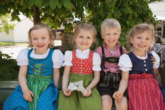 four young kids laughing at the camera and all smiling