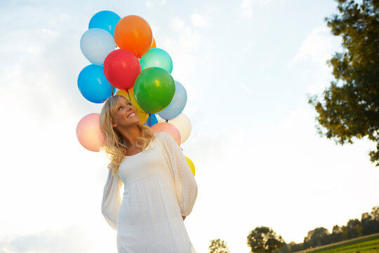 happy young woman with lots of balloons 