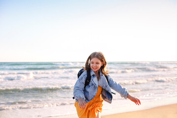 Cute smiling little girl  running on sunny beach, happy little girl, enjoying spending time on summer seaside